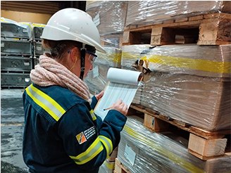 Operaria realizando control de inventario en depósito